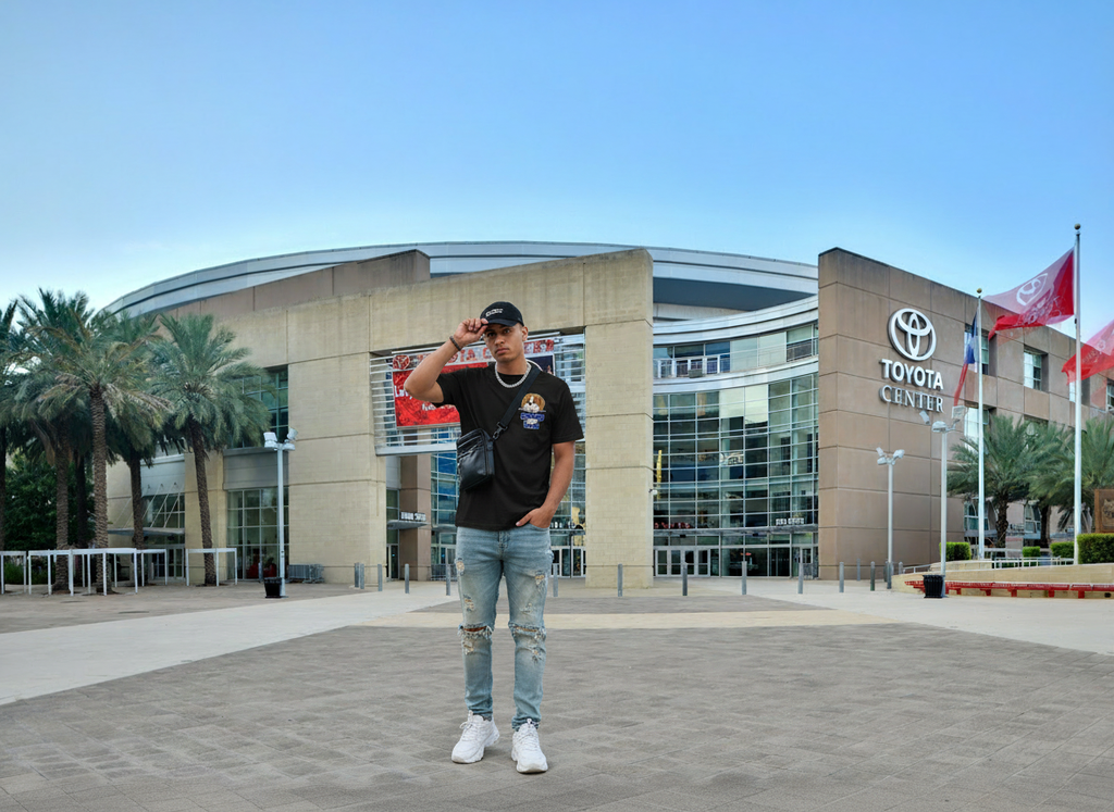 Gen Z male model wearing a black riskiskey mascot graphic tee in front of Houston Toyota Center, styled in a streetwear editorial look