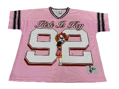 Close-up of the Born Original RiRi the Beagle pink and white jersey showing moisture-wicking fabric, contrast piping, and detailed beagle mascot logo.