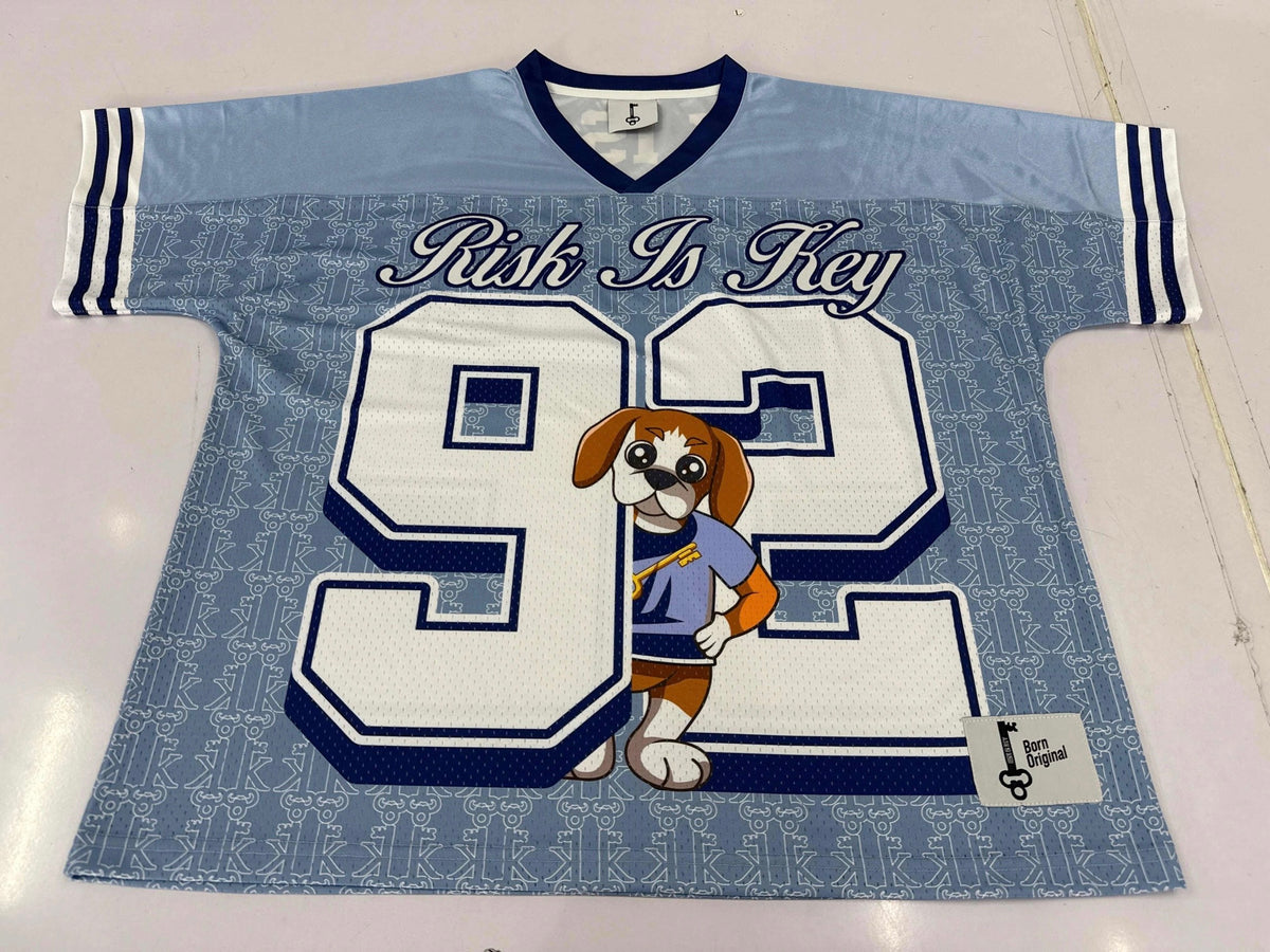Detailed view of the Rik the Beagle mascot logo on the blue and white sports jersey fabric.