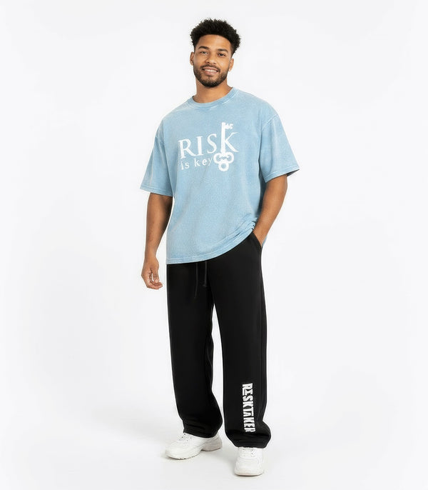 Gen Z male wearing Risk Is Key light blue mineral wash boxy cotton t-shirt with a vintage texture and relaxed streetwear fit.