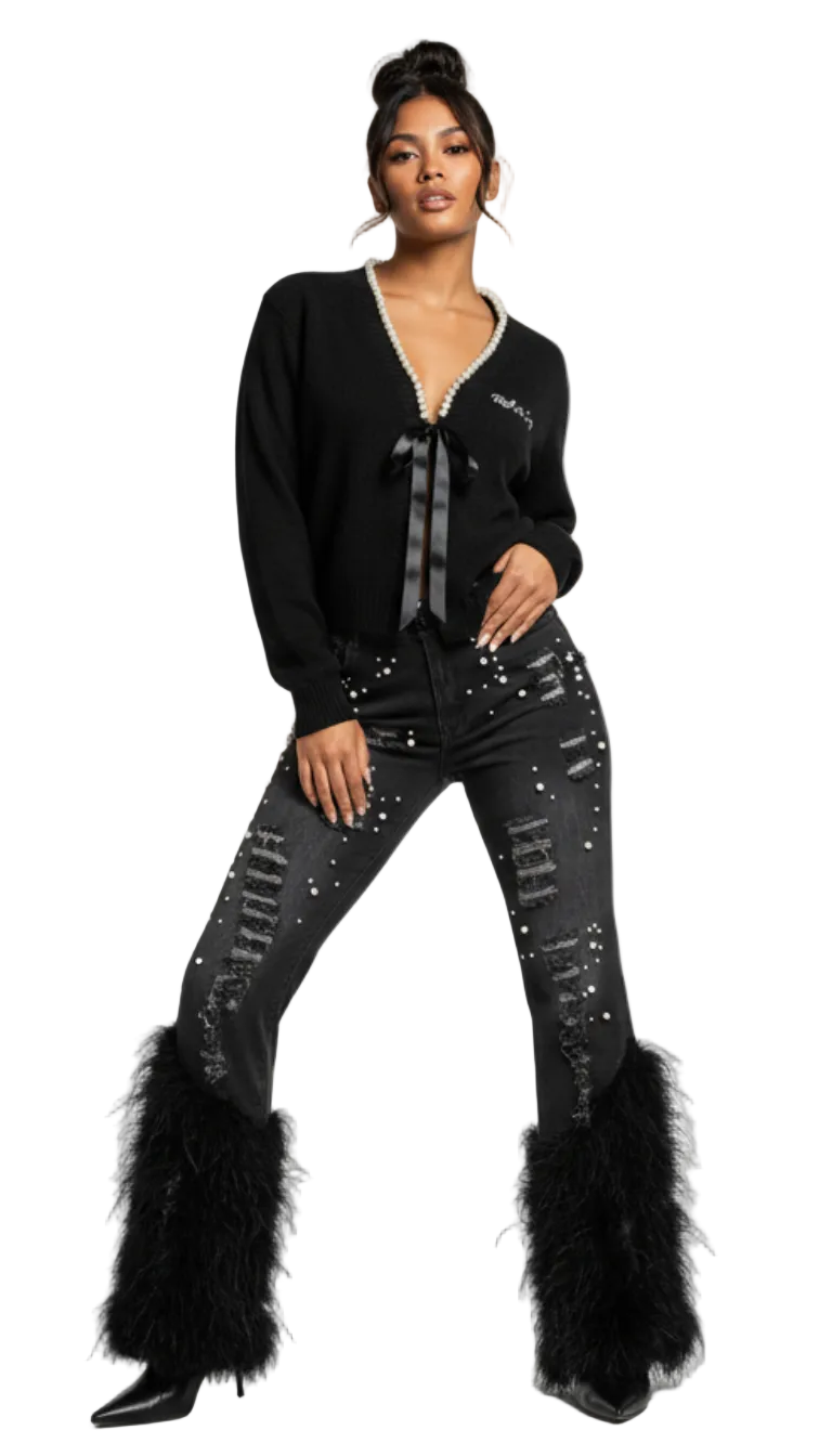 Women's black high-waist flare jeans with edgy distressed details, white pearl accents, and a matching black feather flare hem.