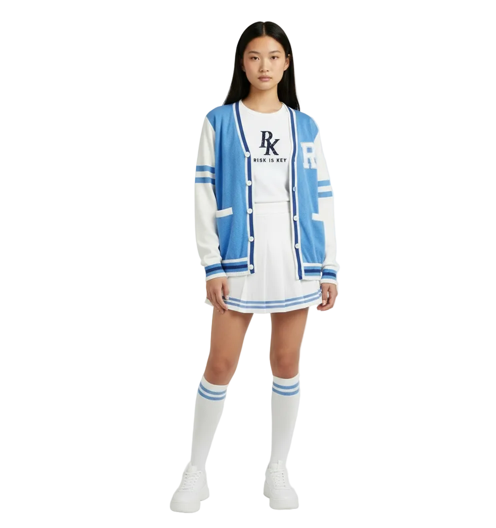 Female model wearing the Risk is Key Unleashed blue and white varsity cardigan with a white pleated skirt, striped knee socks and sneakers.